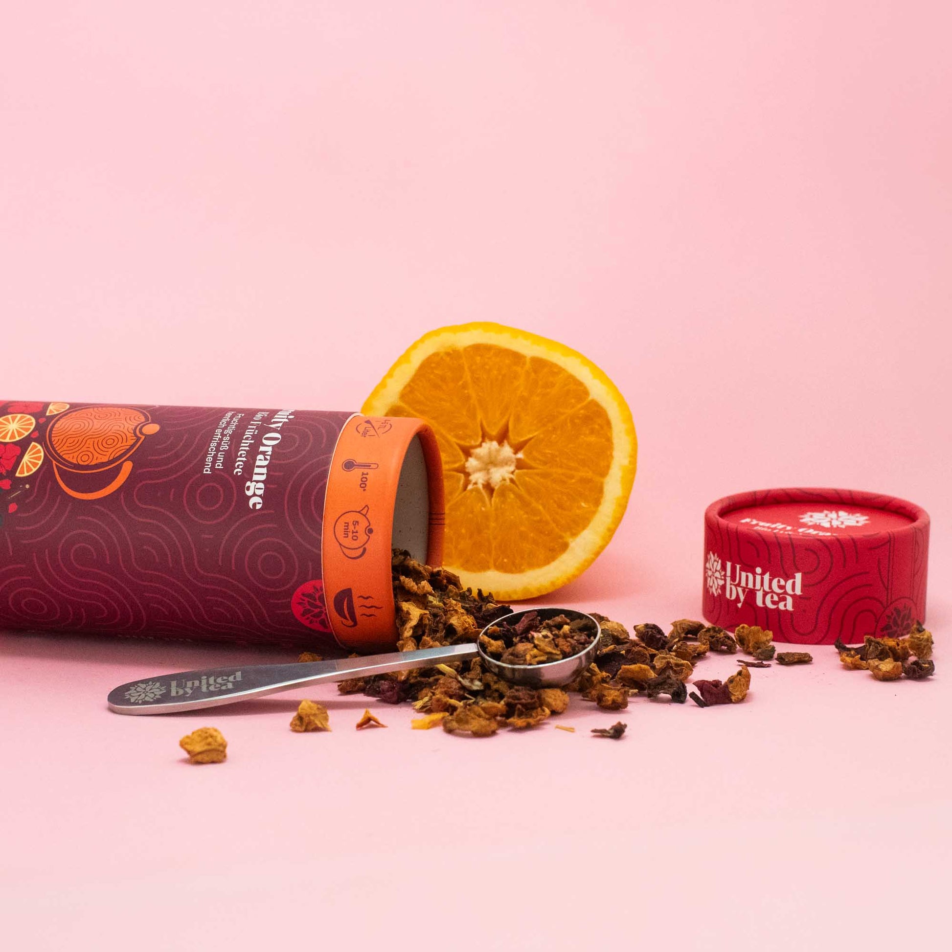 Geöffneter Bio-Tee "Fruity Orange" mit Orange und Teemesslöffel